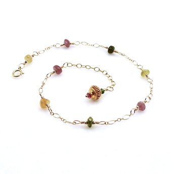 a tourmaline gemstone anklet in mixed colors with an adjustable gold chain dangle