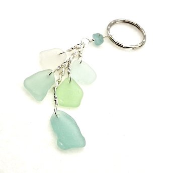 sea glass keychain with five small charms dangling from a sterling silver chain